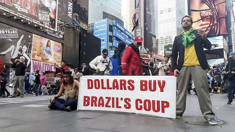 ERRO Grupo. Dollars buy Brazil's Coup. 2016. Ação/protesto: O ERRO Grupo realizou no sábado (30/04/16) em Nova York uma intervenção contra o golpe. A ação foi no Touro de Wall Street, Times Square e Zuccotti Park, em frente ao antigo World Trade Center.